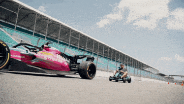 a man is driving a go kart next to a race car that says crypto.com on the side