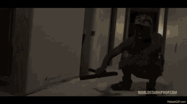 a man in a hat with the letter t on it is walking down a hallway