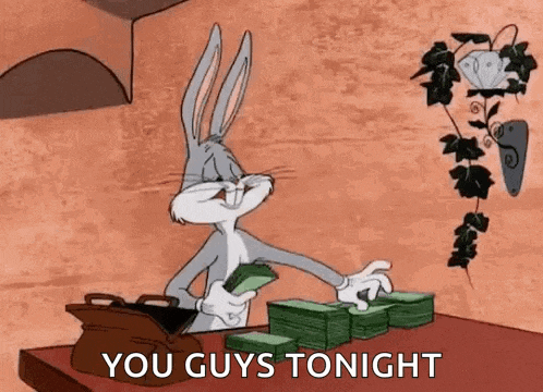 bugs bunny is sitting at a table holding a bag of money and a stack of money .