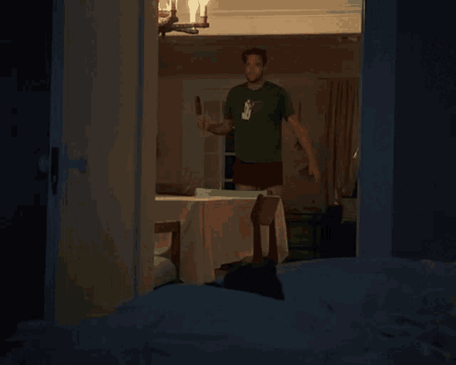 a man is standing in a dark room behind a french door