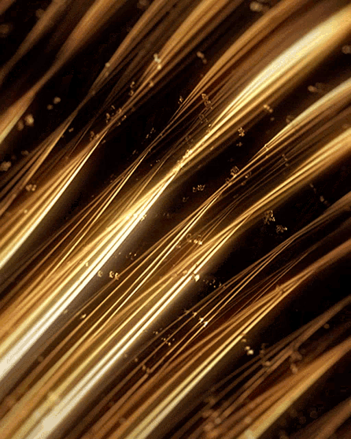 a close up of a gold colored surface with a dark background