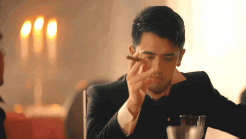 a man in a tuxedo smoking a cigar