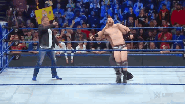 a man in a wrestling ring with a sign that says sdlive