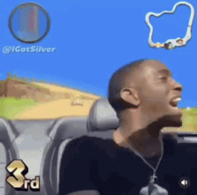 a man is sitting in a car playing a video game with the word 3rd on the screen .