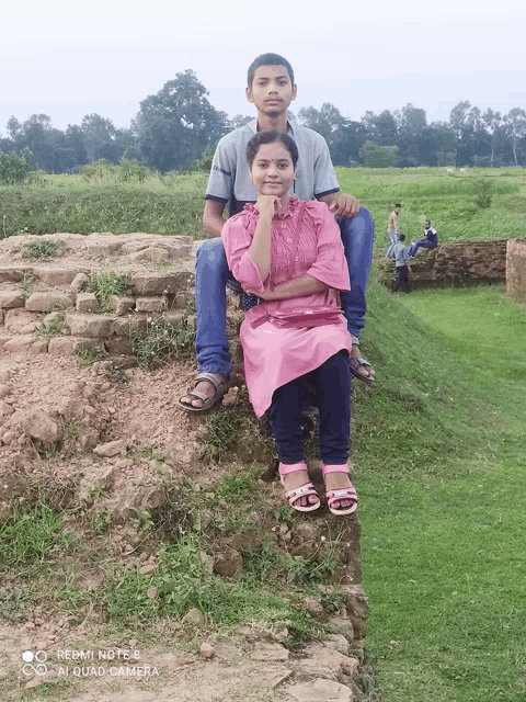 a boy and a girl are posing for a picture with a redmi note 5 camera