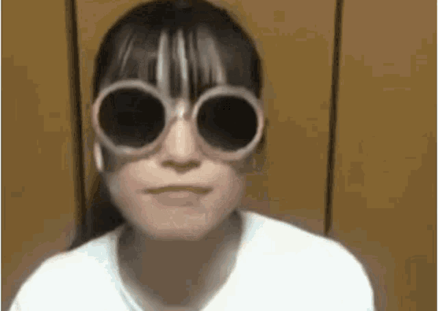 a girl is wearing sunglasses on her face .