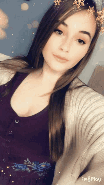 a woman is taking a selfie with a snowflake filter on her head