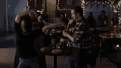 a group of people are sitting at tables in a bar