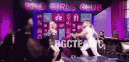 a group of women dancing in front of a sign that says bad girls club