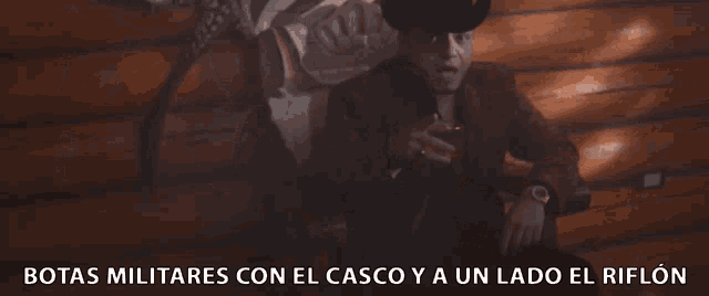 a man in a cowboy hat sits in front of a skeleton and the words botas militares con el casco