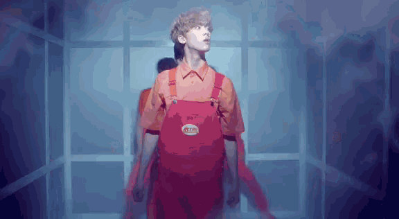 a man wearing red overalls and an orange shirt has a sticker on his shirt that says ' ikea ' on it
