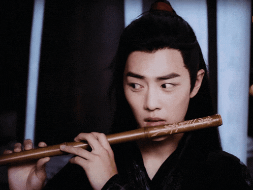 a man playing a flute with chinese writing on it