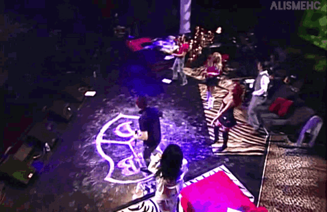 a group of people are dancing on a stage with a logo that says alismehc on the bottom