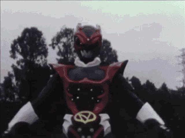 a red and black power ranger with a yellow circle on his belt