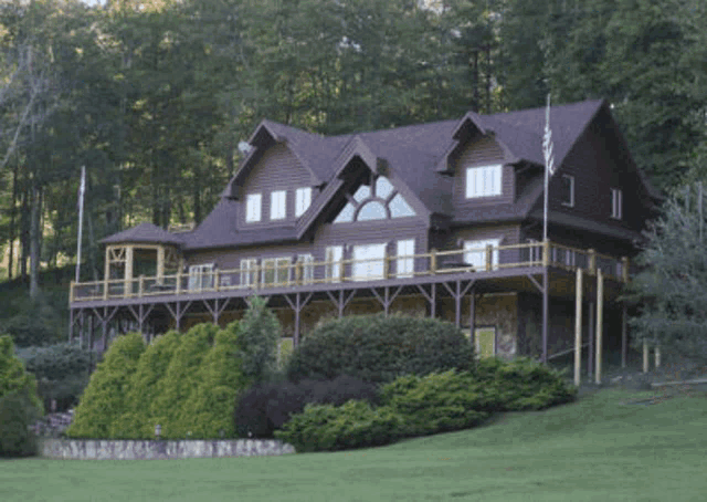 the back of a house with a large deck and patio area .