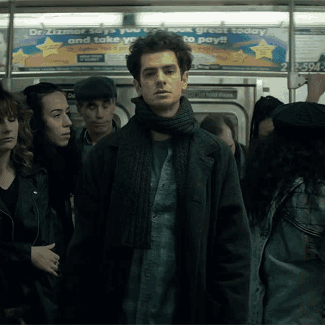 a man on a subway train with an advertisement for dr. zimmerman on the wall behind him