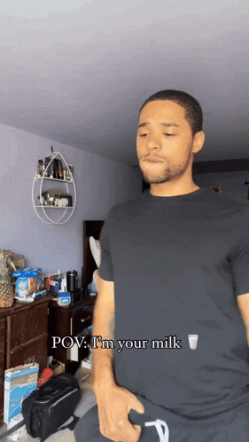 a man in a black shirt says " pov i 'm your milk " in a room