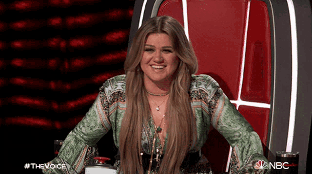 a woman sits in a chair with a nbc logo on the bottom