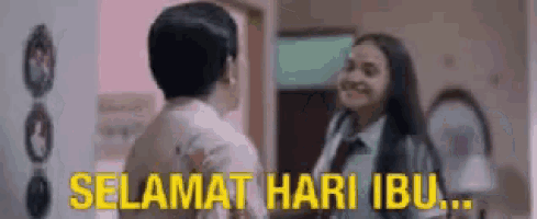 a man and a woman are standing next to each other in a room with the words `` selamat hari ibu '' written in yellow .