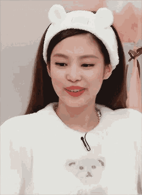 a close up of a woman wearing a white headband with ears .