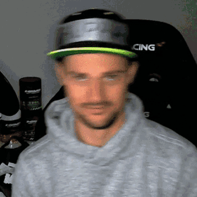 a blurry picture of a man wearing a hat that says racing on it