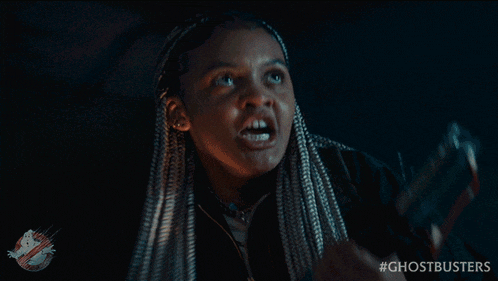 a girl with dreadlocks is holding a flashlight with the hashtag #ghostbusters