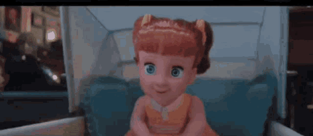 a doll with red hair is sitting in a crib