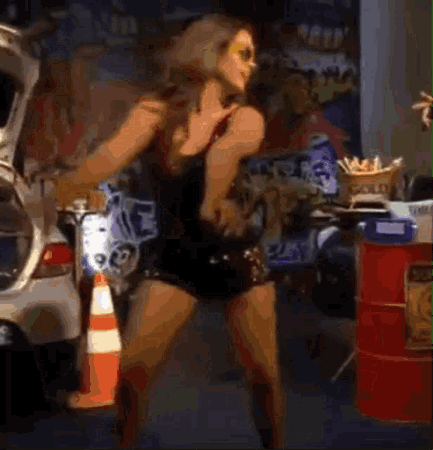 a woman is dancing in front of a red barrel that says sonic