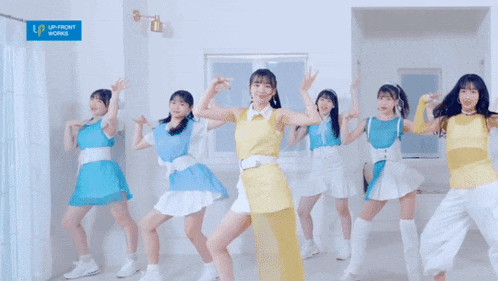 a group of women are dancing in front of a sign that says up front works
