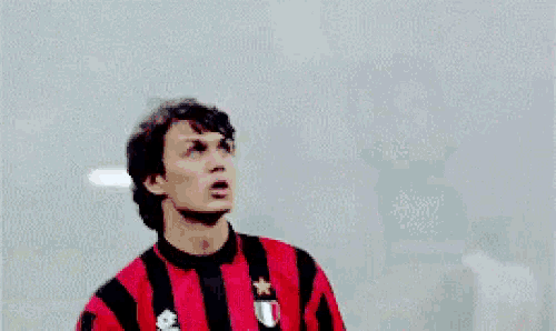 a man is wearing a red and black striped shirt with the word motta on it