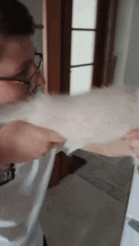 a man with glasses is holding a white dog .