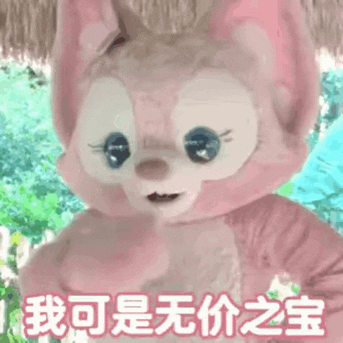 a pink stuffed animal with chinese writing on it is standing in the grass .