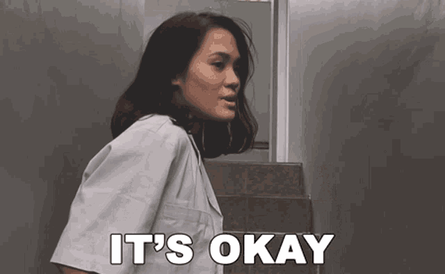 a woman in a lab coat says it 's okay while walking down stairs