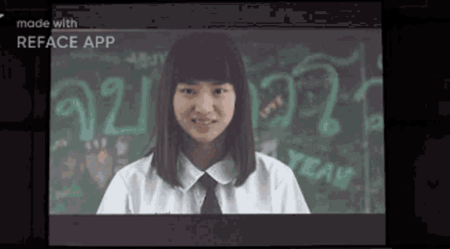 a girl in a white shirt and tie is standing in front of a blackboard in a classroom .