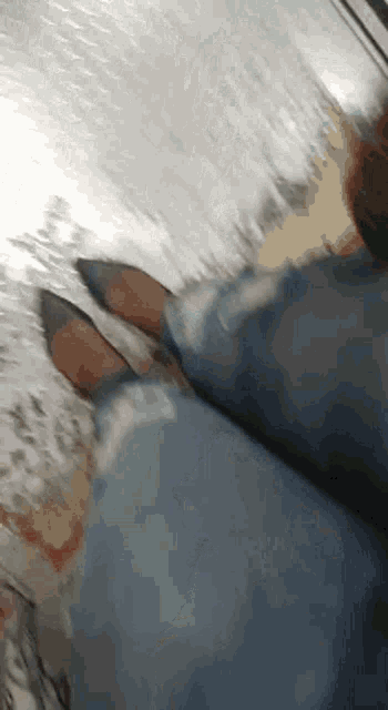 a woman 's feet are shown in a blurry photo while wearing jeans and heels