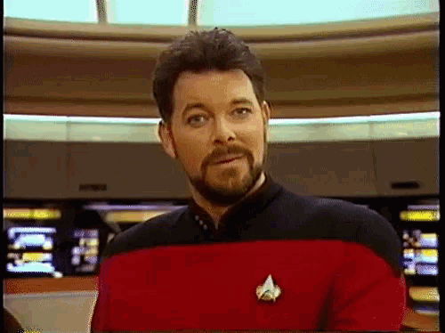 a man with a beard is wearing a red uniform with a star trek logo on it