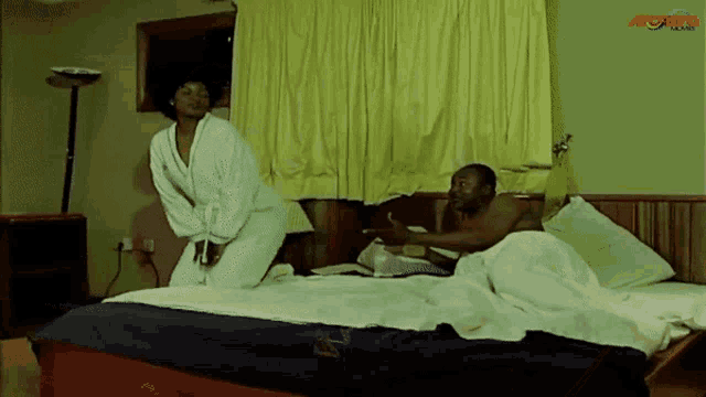 a man and a woman are laying on a bed in a hotel room with a watermark that says aobro