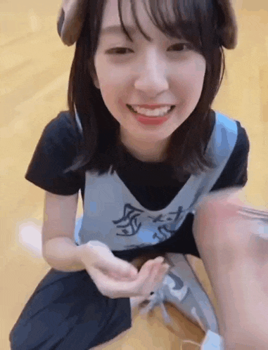 a girl is sitting on the floor wearing a dog headband and smiling at the camera .