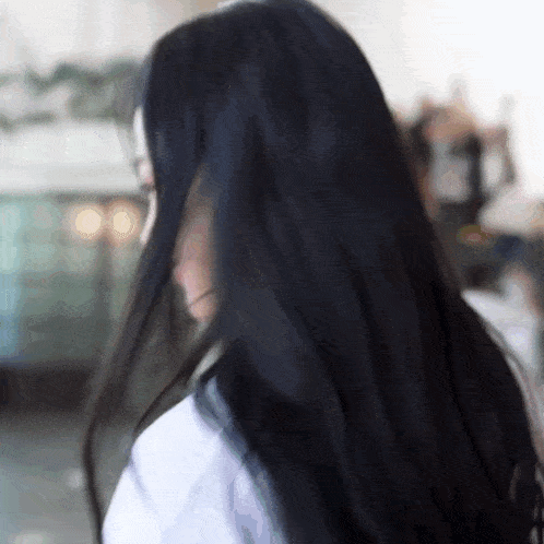 a woman with very long black hair covering her face