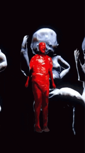 a man in a red bodysuit is standing in front of a group of skeletons