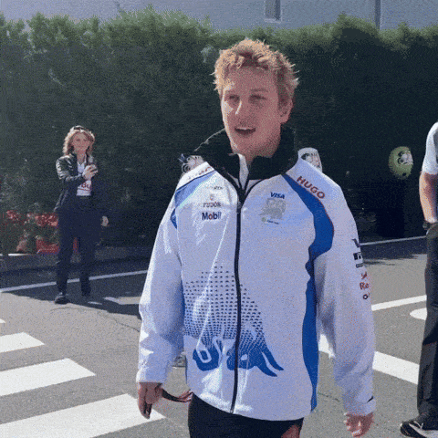 a man wearing a white jacket that says hugo on the sleeve
