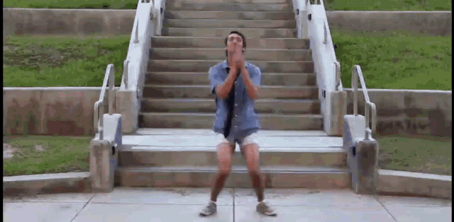 a man in shorts and a tie is standing on a set of stairs