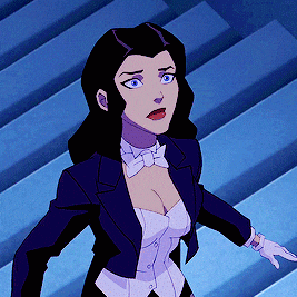 a woman in a tuxedo and bow tie is standing in front of stairs