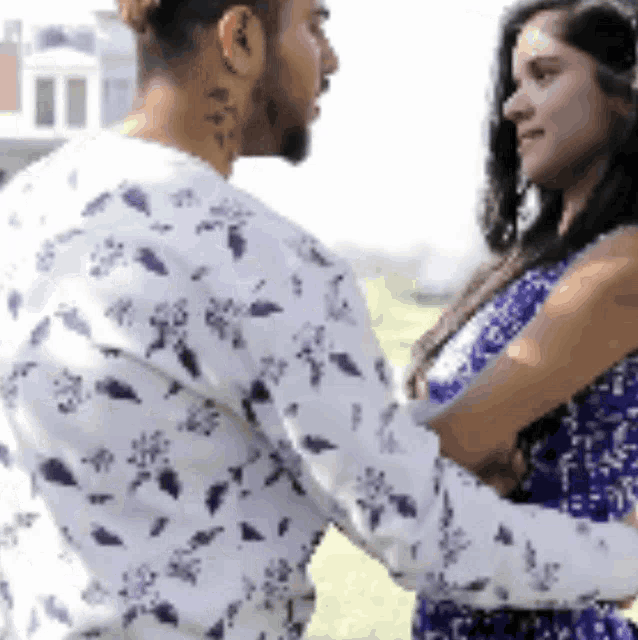 a man and a woman are hugging each other and looking at each other .