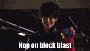 a person in a red sweater is holding a blue object with the words hop on block blast written on it