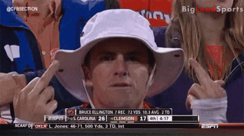 a man wearing a white hat points to a screen that says espn on it