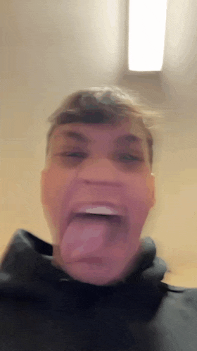 a man is sticking his tongue out and making a funny face .