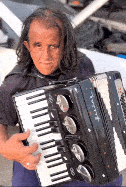 a man with long hair is holding an accordion that says infinity on it