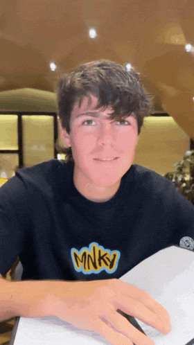a young man wearing a black shirt with the word minky on it