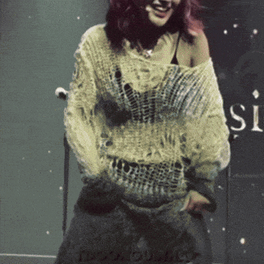 a woman wearing a sweater with the word si on it